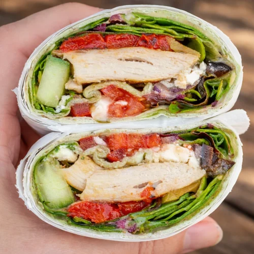 A variety of colorful healthy wraps filled with vegetables and proteins for lunch.
