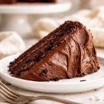 Homemade simple chocolate cake topped with chocolate frosting in a homemade cake