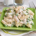 Bowl of easy tuna pasta salad featuring pasta, canned tuna, celery, and red onions.