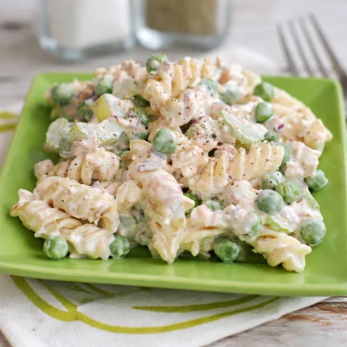 Bowl of easy tuna pasta salad featuring pasta, canned tuna, celery, and red onions.