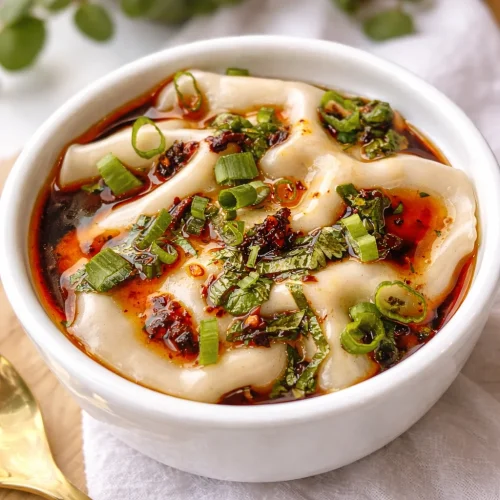 Viral dumpling lasagna with layers of pork and wonton wrappers, a cozy dish.
