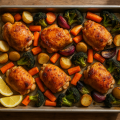 Roasted chicken thighs with potatoes, carrots and broccoli on a sheet pan